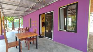 Habitación con mesa y pared púrpura. en Casas Guanacaste Marbella en Marbella