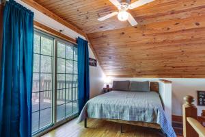 Schlafzimmer mit Holzdecken und einem Bett mit blauen Vorhängen in der Unterkunft Vacation Rental Near Lake Patoka with Hot Tub! in Taswell