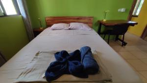 Una cama con dos pares de calcetines azules. en Casas Guanacaste Marbella en Marbella