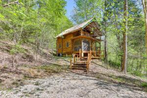 eine Blockhütte im Wald mit einem Weg, der dorthin führt in der Unterkunft Vacation Rental Near Lake Patoka with Hot Tub! in Taswell