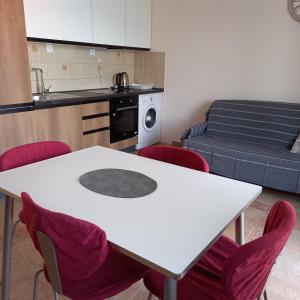 eine Küche mit einem weißen Tisch und roten Stühlen in der Unterkunft Apartman Doris in Krasići