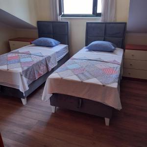 2 Einzelbetten in einem Zimmer mit Fenster in der Unterkunft Apartman Doris in Krasići