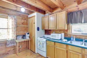 a kitchen with wooden cabinets and a white stove top oven at Comfy Taswell Cabin Rental - Community Amenities! in Taswell