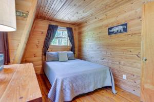 1 dormitorio con 1 cama en una cabaña de madera en Comfy Taswell Cabin Rental - Community Amenities! en Taswell
