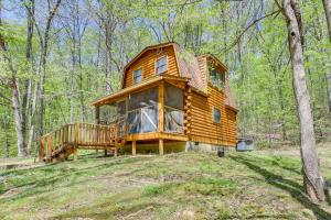 a log cabin in the woods with a large deck at Comfy Taswell Cabin Rental - Community Amenities! in Taswell