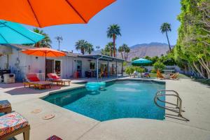 una casa y una piscina con sombrilla y sillas en Palm Springs Getaway with Shared Outdoor Pool!, en Palm Springs