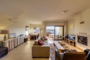 a large living room with a couch and a tv at Vila Vida in Ferragudo