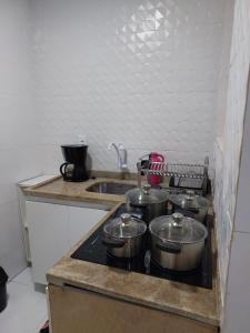 a kitchen with four pots and pans on a stove at Apartamento Copacabana vista lateral mar in Rio de Janeiro