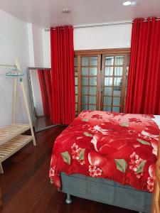 a bedroom with red curtains and a bed with a red blanket at Apartamento Copacabana vista lateral mar in Rio de Janeiro