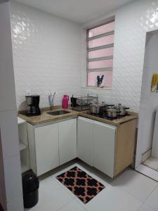 a kitchen with white cabinets and a sink and a window at Apartamento Copacabana vista lateral mar in Rio de Janeiro