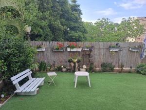 a garden with a bench and a table and a fence at סטודיו במרכז מודיעין in Modi'in