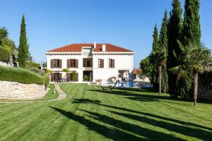 una gran casa blanca con árboles y un patio en Exclusive Villa Marnano - Split center, en Split