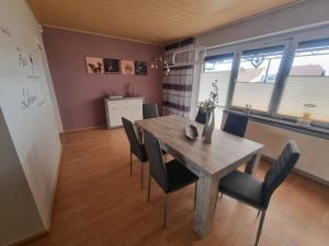 a dining room with a wooden table and chairs at Ferienhaus Pusteblume in Lübben