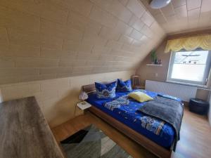 a bedroom with a bed with blue sheets and a window at Ferienhaus Pusteblume in Lübben