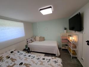 a small bedroom with two beds and a television at Veselá lama U nás doma in Baška
