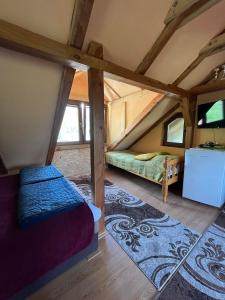Cette chambre mansardée comprend un lit et une table. dans l'établissement Studio apartman - Svetionik, à Vrhpolje