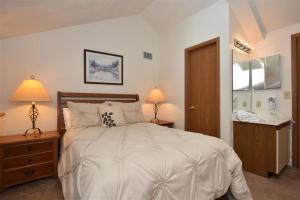 Seven Springs Stoneridge 3 Bedroom & Loft Standard Condo, walking distance to slopes! condo في Champion: غرفة نوم بها سرير أبيض كبير وحمام