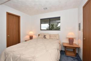 Seven Springs Stoneridge 3 Bedroom & Loft Standard Condo, walking distance to slopes! condo في Champion: غرفة نوم بيضاء بسرير ومصباحين +12 صورة