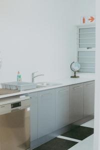 a kitchen with white cabinets and a sink at Oceana View in Swakopmund