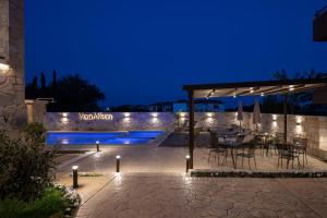 a patio with a table and chairs under a pavilion at night at VagAthan - Lux Holidays in Afitos