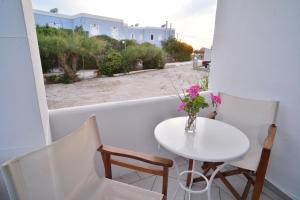 a small white table and chairs on a balcony at George in Galissas