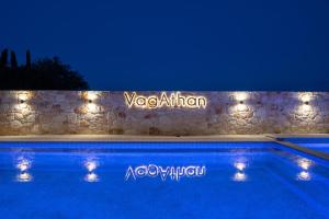 a swimming pool with lights on a stone wall at VagAthan - Lux Holidays in Afitos