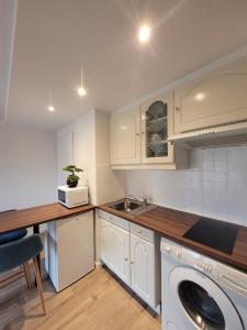 eine Küche mit weißen Schränken, einer Spüle und einem Geschirrspüler in der Unterkunft Claelle Appartment - 300m beach in Mandelieu-la-Napoule