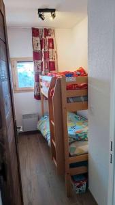 a small room with three bunk beds and a window at Appartement Valmeinier 6pers in Valmeinier
