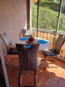 een tafel en stoelen in een kamer met een raam bij studio centre ville proche mer in Vallauris