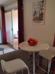 een tafel en stoelen met een kom sinaasappels erop bij studio centre ville proche mer in Vallauris