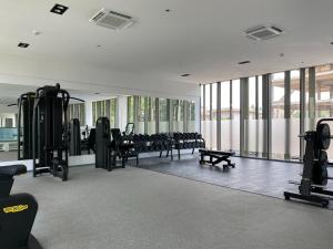 a gym with rows of chairs and equipment and windows at The Lennox Suites by Cozy in Accra