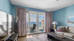 a living room with a couch and a view of the ocean at Sunsational at Laketown Wharf #1924 by Nautical Properties in Panama City Beach