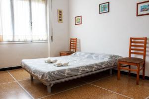 Ce lit se trouve dans une chambre avec 2 chaises et une table. dans l'établissement [Posto Auto e Vista Magnifica] Relax a 900 metri dal mare, à Borgio Verezzi