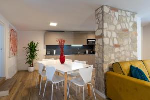 a living room with a white table and chairs and a yellow couch at A CASA DI LUPO in Cison di Valmarino