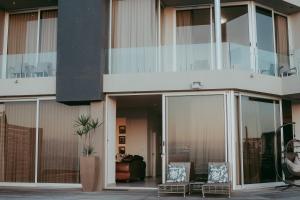 a building with glass doors and chairs in a courtyard at Oceana View in Swakopmund