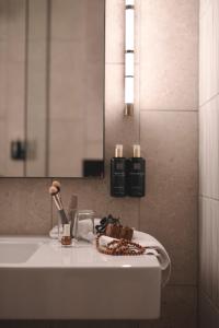 a bathroom counter with a sink and a mirror at Clarion Collection Hotel Tapetfabriken in Stockholm