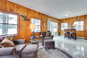 a living room with wood paneled walls and furniture at Lakefront Cabin with Canoes, 7 Mi to Mount Sunapee! in Sunapee