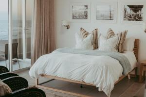 a bedroom with a bed with white sheets and pillows at Oceana View in Swakopmund
