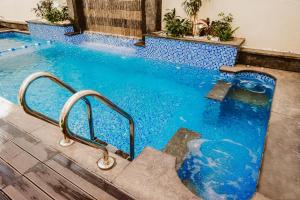 a swimming pool with a blue tiled floor and stairs at M Residence New Cairo - Families only in Cairo