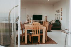 a dining table and chairs in a living room at Oceana View Selfcatering Accommodation in Rand Rifles