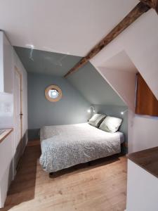 a bedroom with a bed in a attic at Les appartements du centre, refaits à neuf, climatisés, hyper centre, 50m à pieds des commerces, restaurants, parking gratuit in Salies-de-Béarn