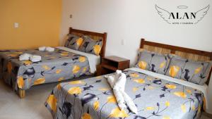 2 camas en una habitación de hotel en Hotel y Cabañas Alan en Chignahuapan