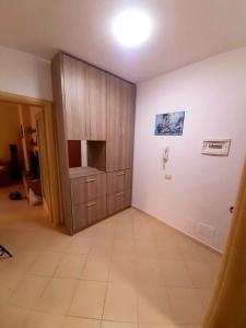 een kamer met een grote kast en een tegelvloer bij Mani Apartment in Durrës