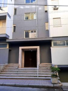 een gebouw met een trap naar een deur bij Mani Apartment in Durrës