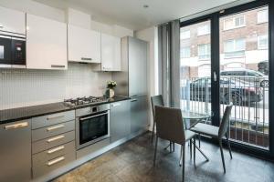 eine Küche mit einem Tisch und ein Esszimmer mit einem Fenster in der Unterkunft Superb Retreat Flat Central in London