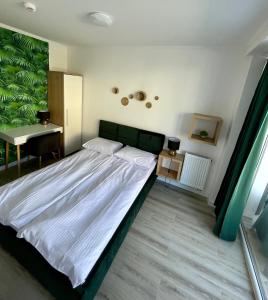 a bedroom with a large bed and a desk at Natura Park in Jastrzębia Góra