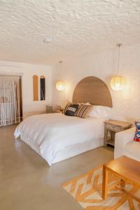 a bedroom with a large white bed and a couch at Bora Bora Beach Club & Hotel in Isla Grande