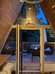 an open door to a deck in a cabin at Glamping Holiday House with hot tub and sauna- Hisa oddiha in Smarjeske Toplice