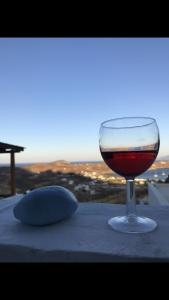 ein Glas Wein auf einem Tisch in der Unterkunft The View Spot in Serifos Chora