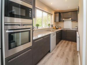 uma cozinha com electrodomésticos em aço inoxidável e pisos em madeira em Kilmory Lodge em Poulton le Fylde